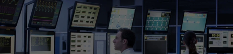 People work in a dark control room