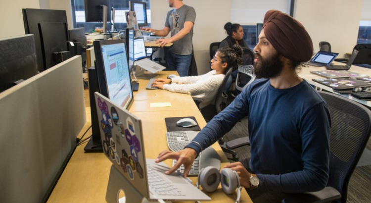 Several coworkers work at computers in an open office