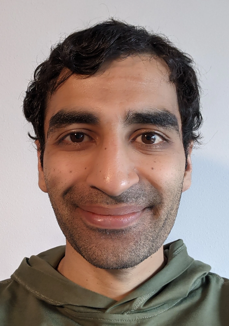 a close up of a man who is smiling and looking at the camera