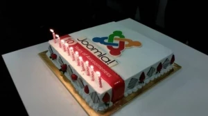 cake with 10 lit candles that reads "Joomla! Ten years of awesomeness"