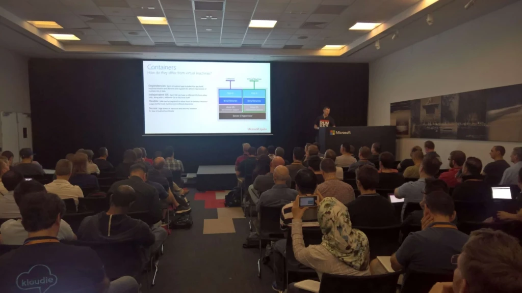 a group of people in a room watching a presentation