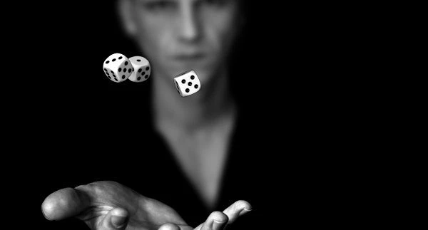 a close up of a person tossing three dice in the air