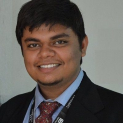 a man wearing a suit and tie smiling at the camera