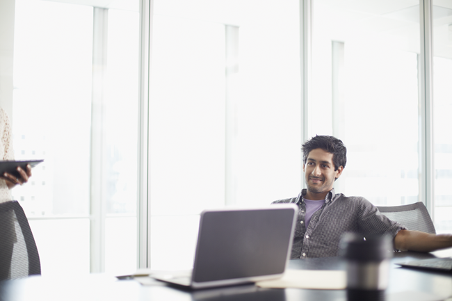 a man standing in front of a laptop