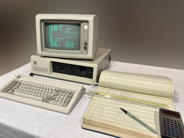 Image of an 86-DOS artifact next to an IBM PC.