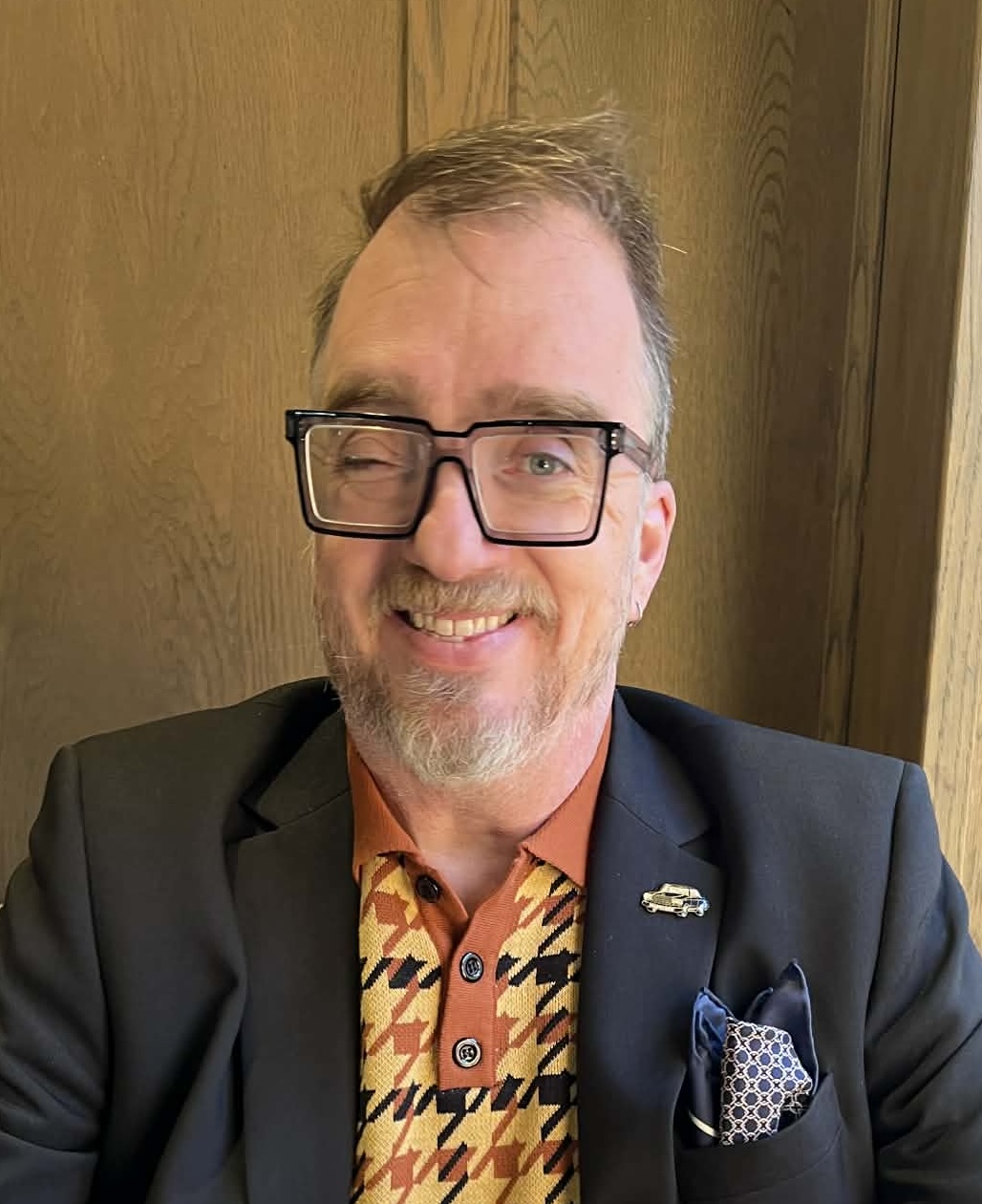 Robert Standefer wearing a suit and glasses.